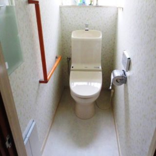 L型手摺と壁内収納のついた機能的なトイレ