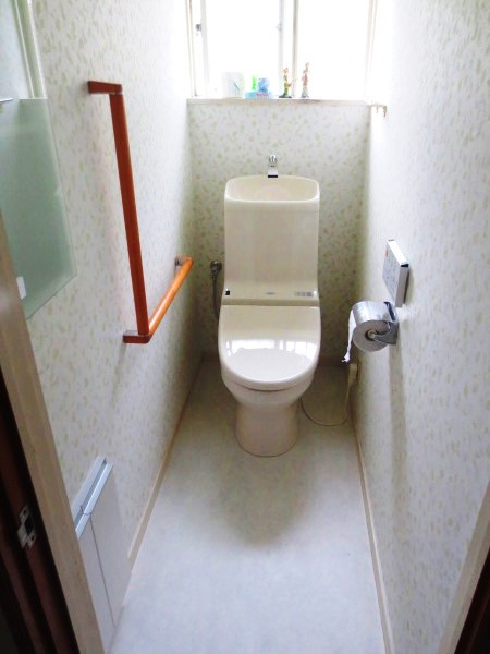 L型手摺と壁内収納のついた機能的なトイレ